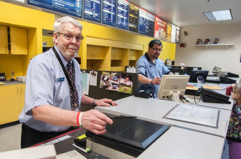 2 postal clerks working at a post office